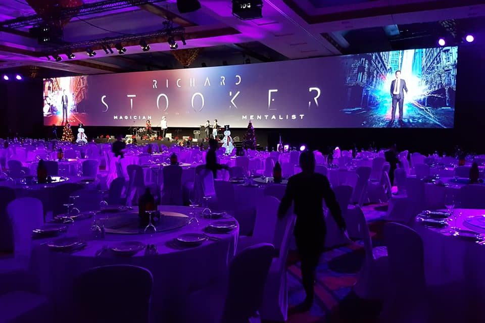 A large gala banquet hall with stage lighting